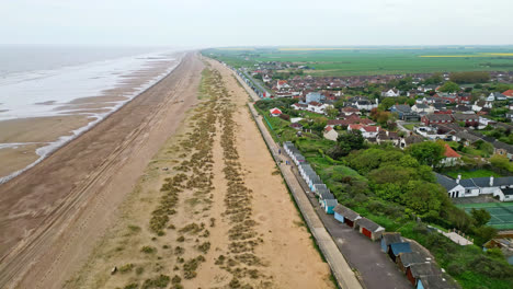 Aerial-footage-brings-Mablethorpe-to-life,-highlighting-beach-huts,-sandy-beaches,-amusement-parks,-rides,-and-the-joyful-tourist-atmosphere