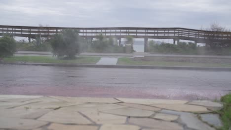 Slow-motion-shot-of-cars-driving-by-flooded-street-after-strong-rain-in-Uruguay,South-Amerikas,-low-angle-shot