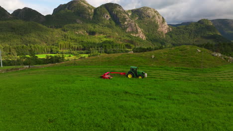 Green-tractor-with-mower-conditioner-harvesting-green-field,-silage-production