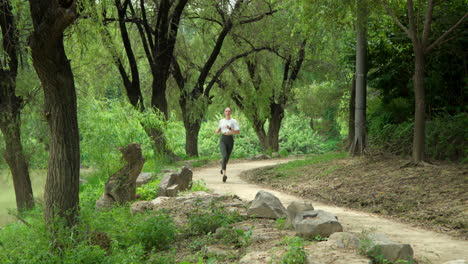Fit-Young-Woman-Running-in-A-Park-By-the-River-in-Slow-Motion