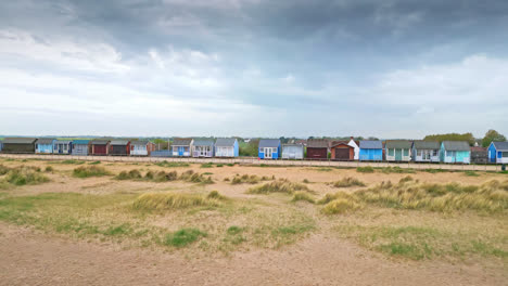 Behold-aerial-views-of-Mablethorpe's-coastal-elegance,-showcasing-beach-huts,-sandy-beaches,-amusement-parks,-rides,-and-the-vibrant-tourists