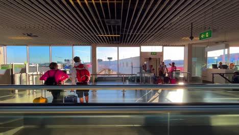 People-walking-on-a-treadmill-at-Schiphol-airport-on-their-way-to-their-plane