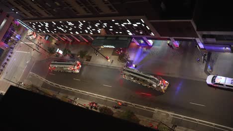 Two-fire-trucks-and-police-car-blocking-a-road-by-a-city-building