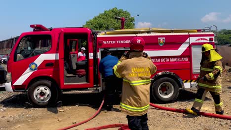 Team-Von-Feuerwehrleuten-Mit-Wassertank-Während-Der-Brandbekämpfung-Auf-Einem-Ländlichen-Feld-In-Indonesien
