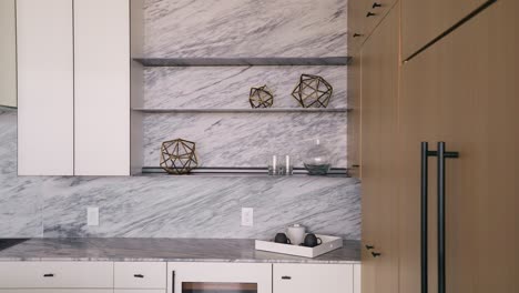 Panning-shot-of-modern-decorations-adorning-shelves-in-a-white-and-luminous-kitchen