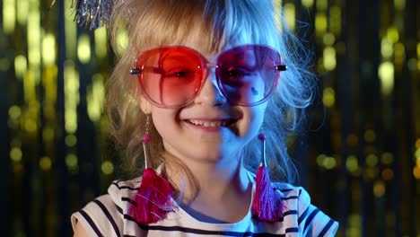 Portrait-of-trendy-stylish-girl-looking-at-camera,-smiling,-child-kid-in-neon-light-at-disco-club