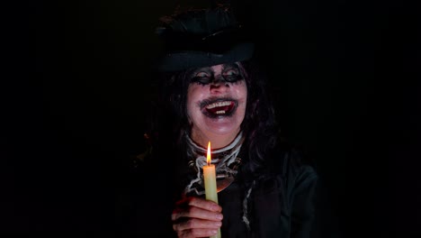 Unheimliche-Alte-Reife-Frau-Im-Karnevalskostüm-Einer-Halloween-Hexe,-Die-Magische-Rituale-Mit-Kerze-Durchführt