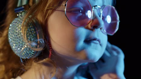 Stylish-trendy-child-kid-in-sunglasses-at-disco-party-cyberpunk-club-looking-at-camera-and-smiling