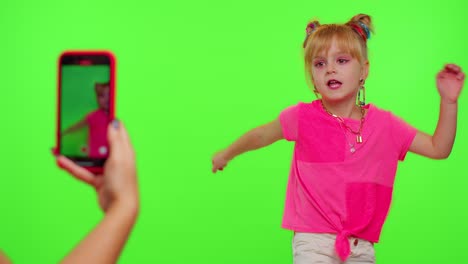 Happy-funky-blogger-child-kid-girl,-recording-funny-dancing-video-on-smartphone-for-social-network