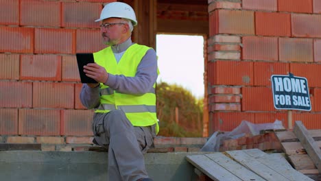 Builder-engineer-architect-operate-with-digital-tablet-to-control-working-at-construction-house-site