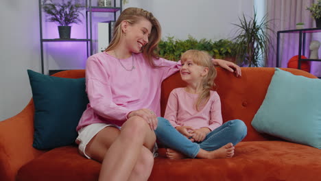 Young-woman-mother-having-trustworthy-conversation,-talking-with-daughter-child-kid-at-home-sofa