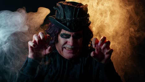 Finsterer-Mann-Mit-Schrecklich-Gruseligem-Halloween-Hexer-Make-up-Im-Kostüm,-Das-Gesichter-Macht-Und-Versucht,-Angst-Zu-Machen