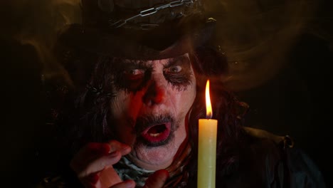 Finstere-Frau-Mit-Gruseligem-Halloween-Hexen-Make-up-Im-Kostüm,-Die-Voodoo-Zauberrituale-Mit-Kerze-Durchführt