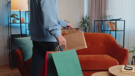 Happy-elderly-man-shopaholic-consumer-came-back-home-after-online-shopping-sale-with-bags-at-home