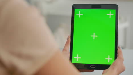 Close-up-of-woman-hands-holding-tablet-computer-with-mock-up-green-screen