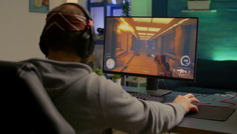 Back-of-pro-gamer-playing-first-person-shooter-video-game