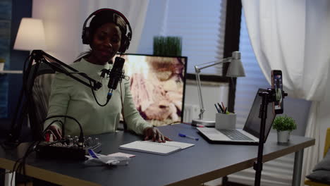 African-influencer-wearing-headphones-checking-sound-recording-new-podcast