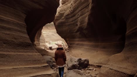 Woman-walking-inside-in-ravine-with-big-stones"