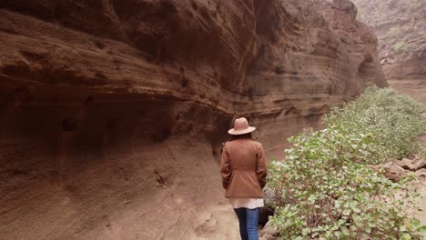 Woman-walking-inside-in-ravine-with-big-stones"
