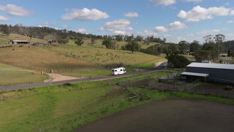 Aerial-view-of-camper-van-driving-on-rural-road-in-countryside-area-of-Australia-during-sunny-day