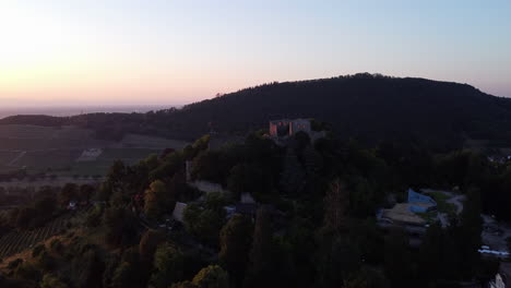 Aerial-sunset-view-of-Burg-Baden-on-hillside-overlooking-picturesque-Kurpark