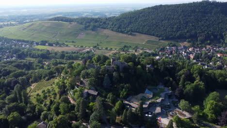 Ruins-of-Burg-Baden-or-Badenweiler-Castle-fortification-atop-lush-hill,-drone