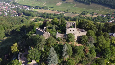 Aerial-arc-view-of-Badenweiler-castle-ruins-on-hillside,-Germany