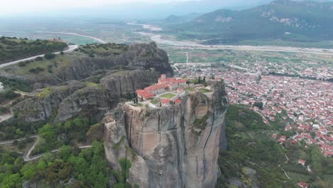Aerial-Of-Meteora:-Drone-Circling-A-Greek-Orthodox-Monastery-Suspended-Above-The-City-Of-Kalambaka,-Greece