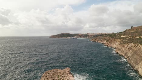 Drone-retreats,-exposing-immense-sea-rock-near-Gozo's-coast