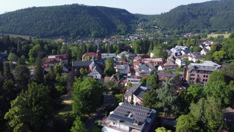 Spa-town-of-Badenweiler-in-lush-forested-countryside,-aerial-trucking-shot