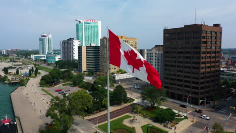 Aerial-view-of-a-Canadian-flag-in-front-of-the-Windsor-city-skyline-in-Canada