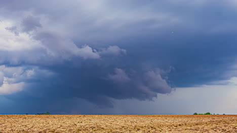 Zeitrafferwolken,-Die-über-Der-Mit-Blauem-Licht-Beleuchteten-Ackerlandschaft-Lettlands-Wirbeln-Und-Sich-Bilden