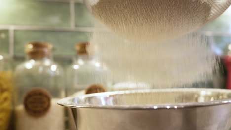 Baking-preparation-by-sifting-flour-into-a-kitchen-bowl