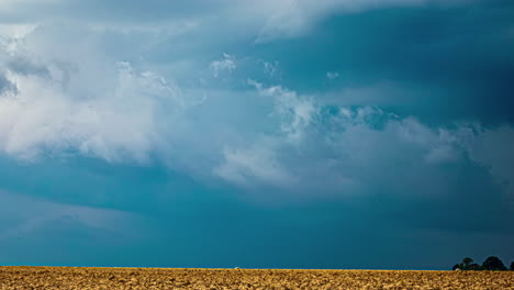 Zeitraffer-Dramatischer-Wolken,-Die-In-Blauem-Licht-über-Weiten-Feldern-Erstrahlen