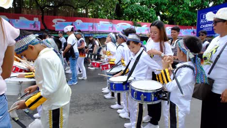 Eine-Gruppe-Junger-Philippinischer-Kinder-Stand-In-Begleitung-Ihrer-Eltern-Auf-Der-Straße,-Um-Während-Des-Davao-City-Festivals-An-Einer-Parade-Teilzunehmen