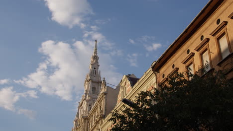 Budapest-Hermosa-Torre-De-La-Iglesia-Y-Fachadas-De-Edificios-Barrocos,-Panorámicas-Hacia-El-Cielo