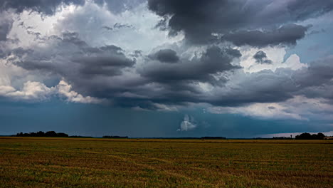 Der-Zeitraffer-Zeigt-Spektakuläre-Wolkenbildung-über-Ackerland,-Während-Traktoren-Die-Felder-Pflügen