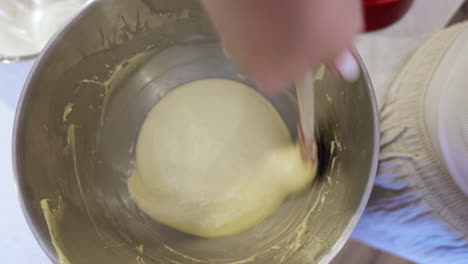 Mixing-of-creamy-cake-ingredients-by-hand-in-metal-bowl-Home-baking-POV