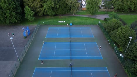 Sportler-Trainieren-Und-üben-Tennis-Auf-Blauen-Außenplätzen,-Aus-Der-Luft