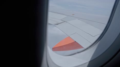 High-altitude-view-over-airplane-wing-from-window-seat,-aviation