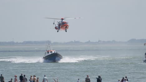 Zuschauer-Am-Strand-Beobachten-Die-Übung-Der-Küstenwache-Mit-SAR-Hubschrauber-Und-Rettungsbooten