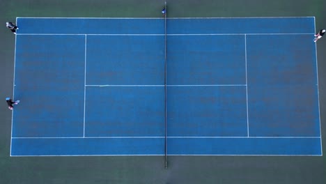 Athletes-Playing-on-Blue-Tennis-Court---Overhead-Aerial-View