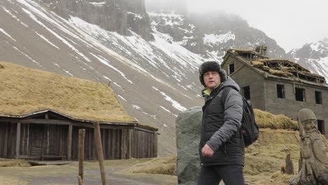 Man-Walking-in-Viking-Village-Replica,-Tuf-Houses-and-Settlement-in-Countryside-of-Iceland-50fps