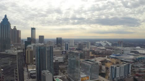 Aerial-drone-shot-slowly-flying-over-skyscrapers-looking-out-over-downtown-Atlanta,-Georgia-with-popular-destinations-below