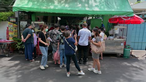 Customers-queuing-and-waiting-for-their-orders-of-the-famous-Thai-papaya-salad,-with-grilled-pork-and-chicken-served-in-the-streets-of-Bangkok
