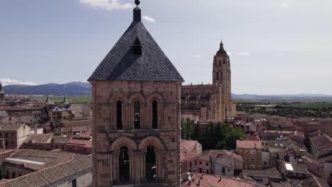 Luftaufnahme-Des-Kirchturms-Von-San-Esteban-Mit-Blick-Auf-Die-Kathedrale-Von-Segovia-Im-Hintergrund-An-Einem-Sonnigen-Tag