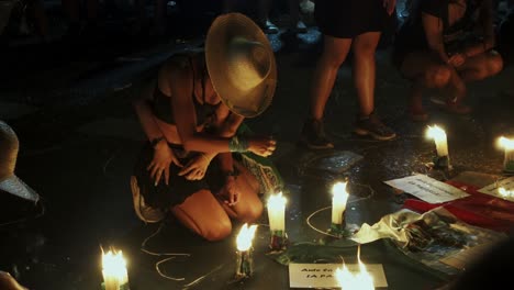 young-woman-mourns,-breaks-down,-cries-in-night-vigil-with-candles-while-another-woman-hugs-her,-she-holds-her-Mexican-hat-at-abortion-rally