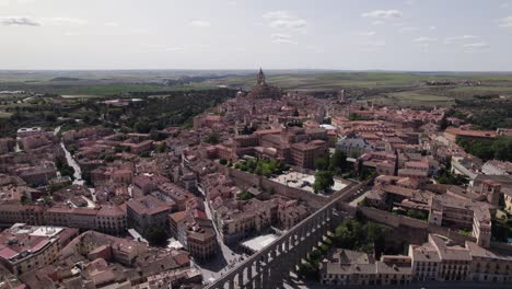 View-Of-Aqueduct-Of-Segovia-Beside-Plaza-Oriental-Surrounded-By-City-Landscape-On-Clear-Sunny-Day