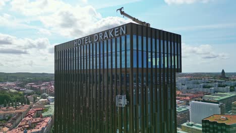 Aerial-of-window-cleaners-suspended-in-a-cradle-outside-of-the-Hotel-Draken,-Gothenburg,-Sweden