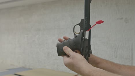 Man-safely-showing-a-empty-handgun-with-a-chamber-flag-and-clear-magazine-well